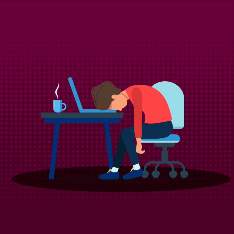 An employee slumped on their desk, clearly disengaged with their work